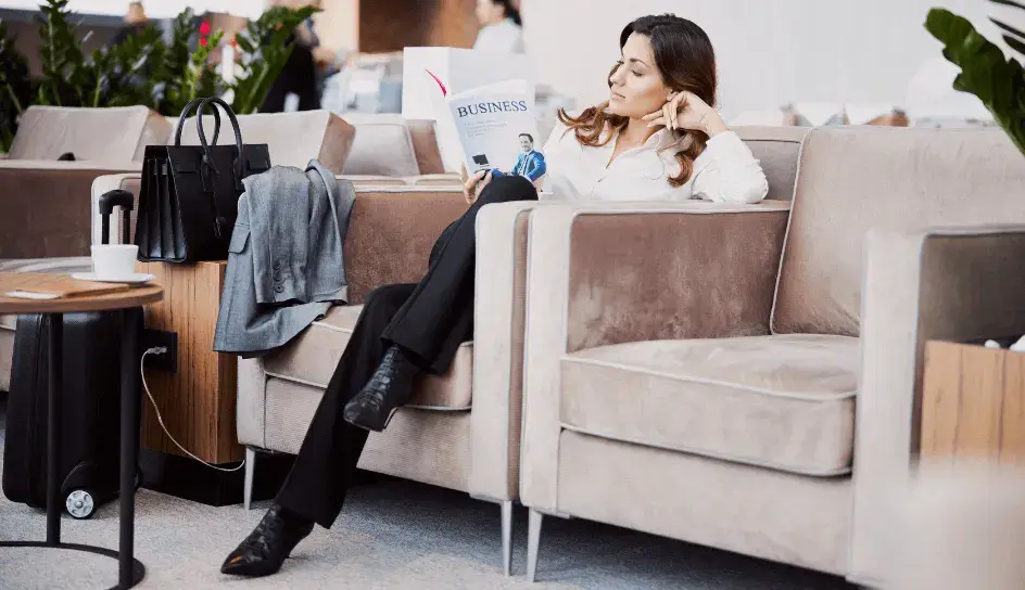 businesswoman relaxing in an airport lounge knowing that her travel voucher is ready and easy to use