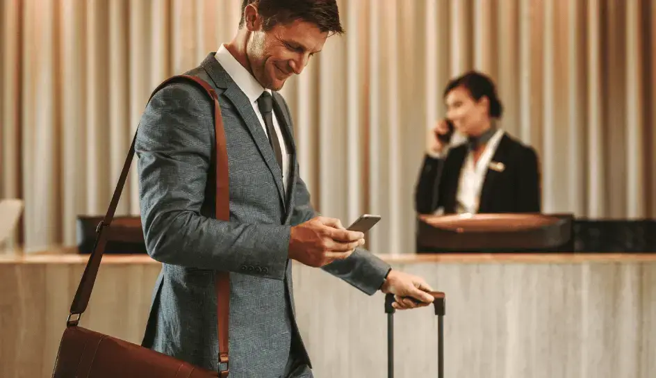 corporate traveller smiling before checking into their hotel because their accommodation has been paid for